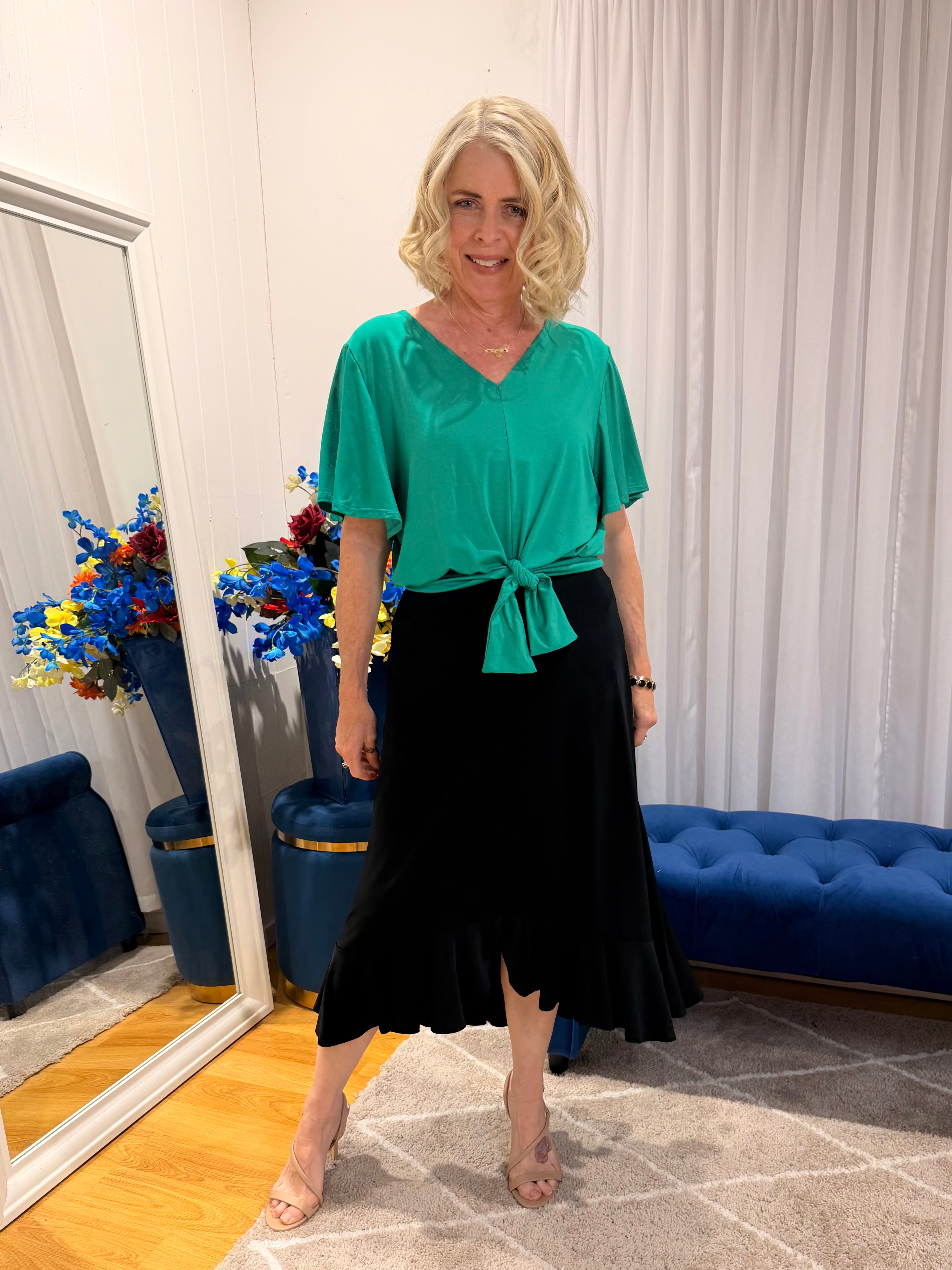 Woman wearing green top and black skirt