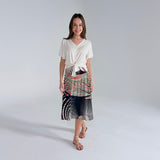 Woman wearing a white top and patterned skirt on a white background