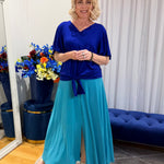 Woman wearing blue top and green skirt 