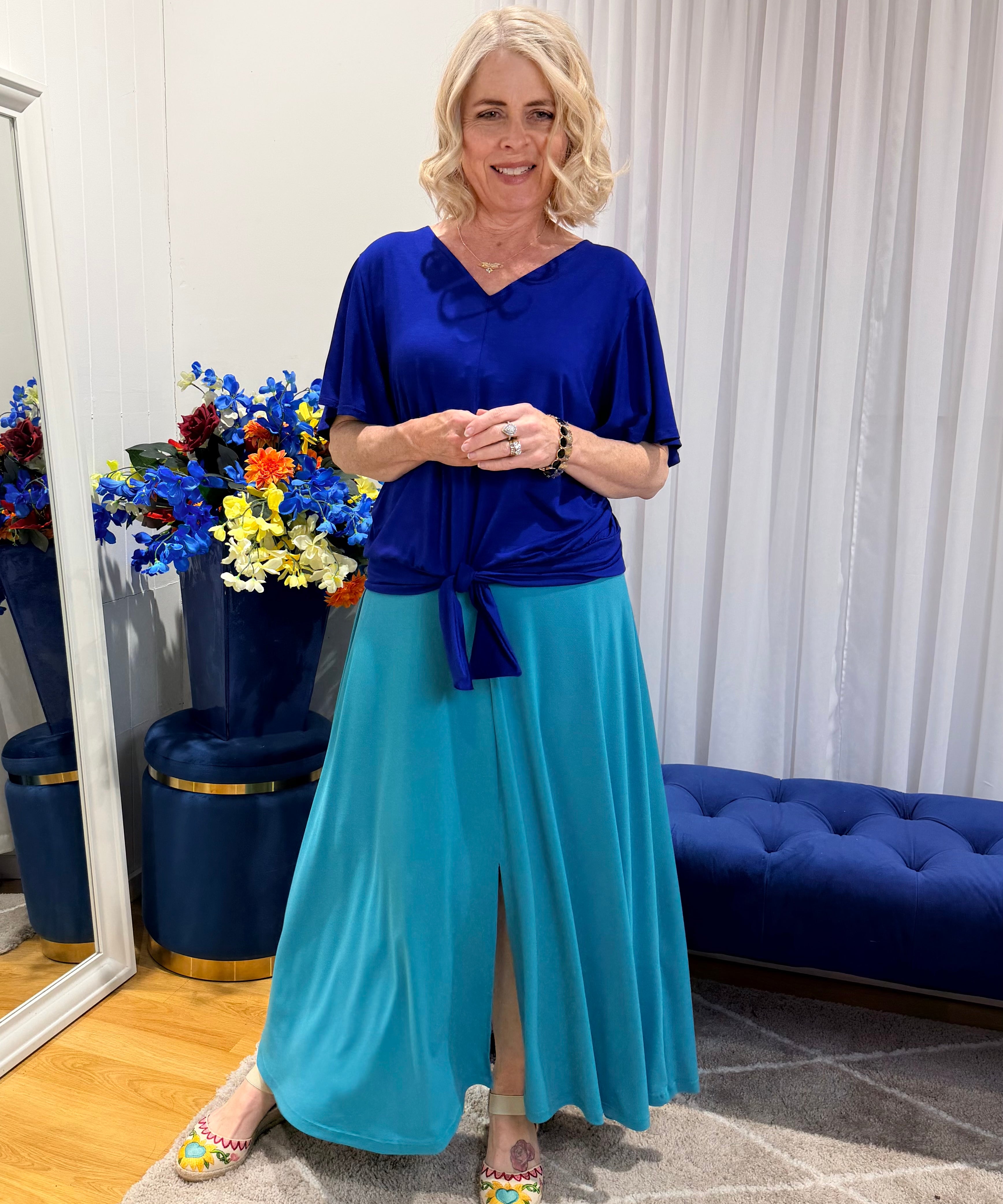 Woman wearing blue top and green skirt 