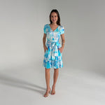 Woman wearing a blue and white patterned dress on a gray background