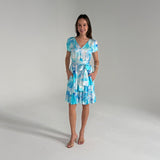 Woman wearing a blue and white patterned dress on a gray background