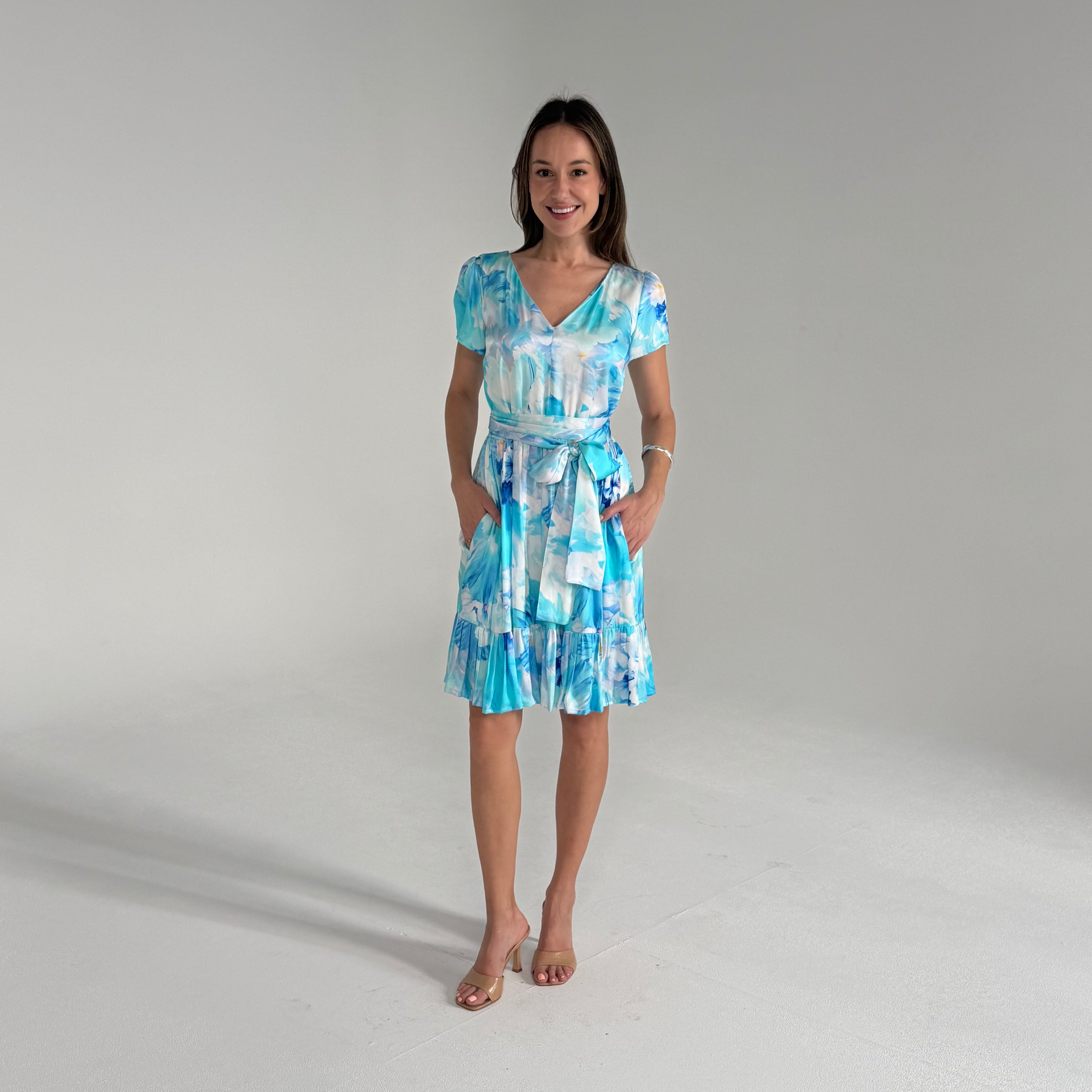 Woman wearing a blue and white patterned dress on a gray background