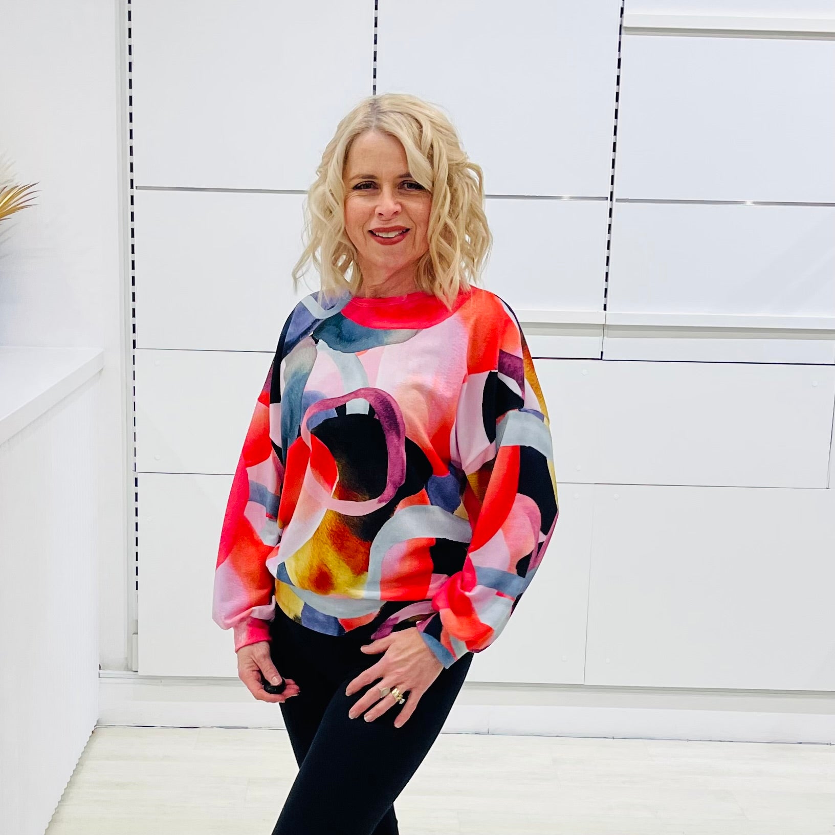 Woman wearing a colorful sweater against a white background
