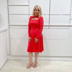 Bright watermelon pink Penelope dress on model- vibrant colour, stretch dress, with feminine silhouette, long sleeve, a-line skirt and keyhole neckline.