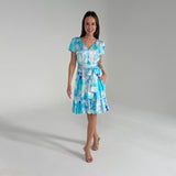 Woman wearing a blue and white patterned dress on a gray background