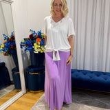 Woman wearing white top and purple skirt 