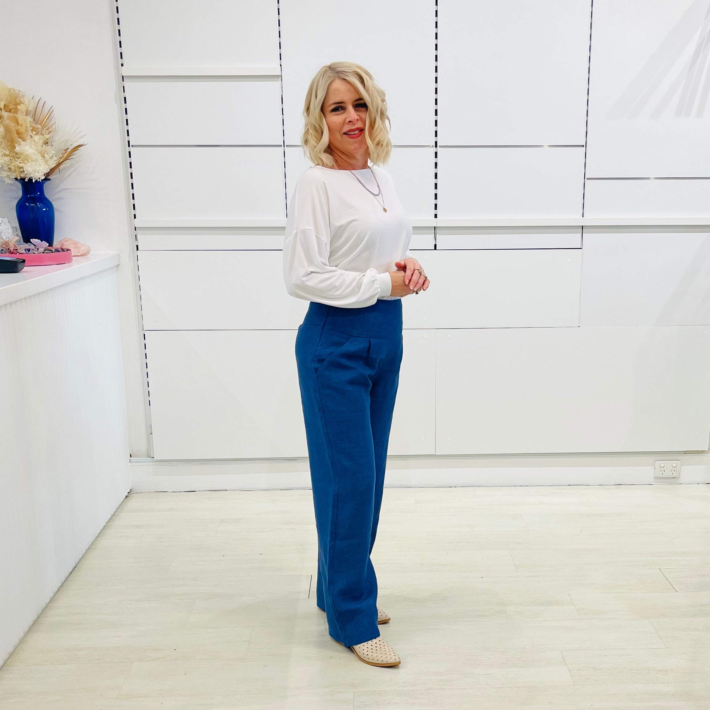 Denim blue,wide leg linen pants with flat waistband, zipper opening and pockets,worn with white bamboo, relaxed fit, long sleeve Gracie top.