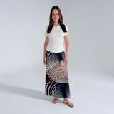Woman wearing a long, patterned skirt on a plain background