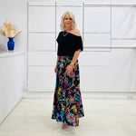 Long, maxi, full circle skirt in multicolored print, flat fitted waistband . Worn with black off the shoulder top.