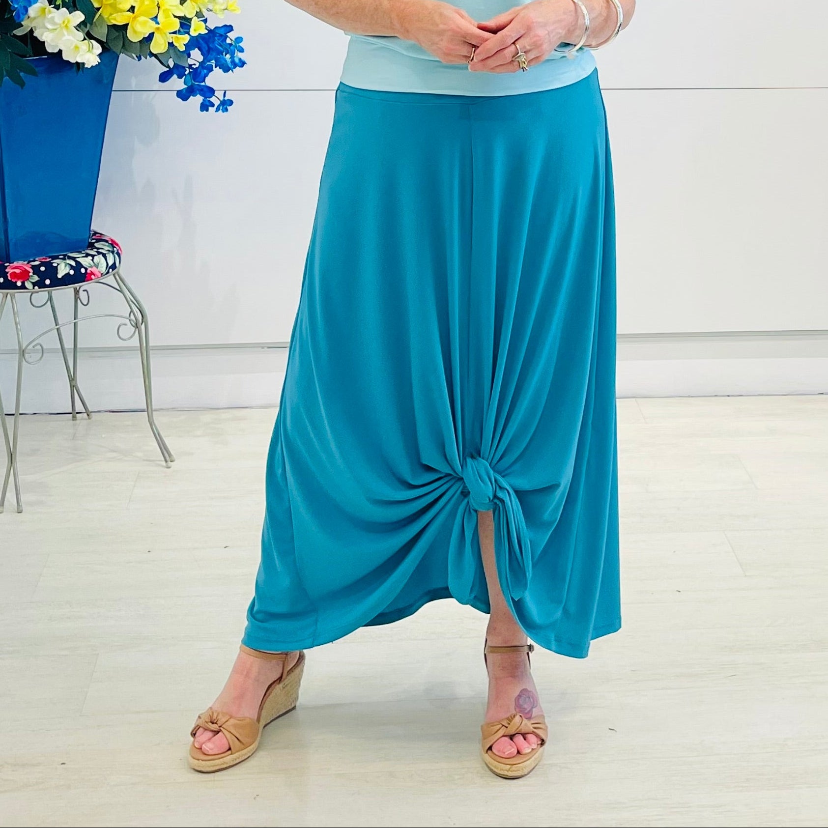 Woman wearing a blue outfit with a white background and decorative elements.