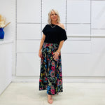 Long, maxi, full circle skirt in multicolored print, flat fitted waistband . Worn with black off the shoulder top.