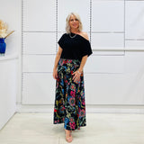 Long, maxi, full circle skirt in multicolored print, flat fitted waistband . Worn with black off the shoulder top.