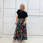 Long, maxi, full circle skirt in multicolored print, flat fitted waistband . Worn with black off the shoulder top.