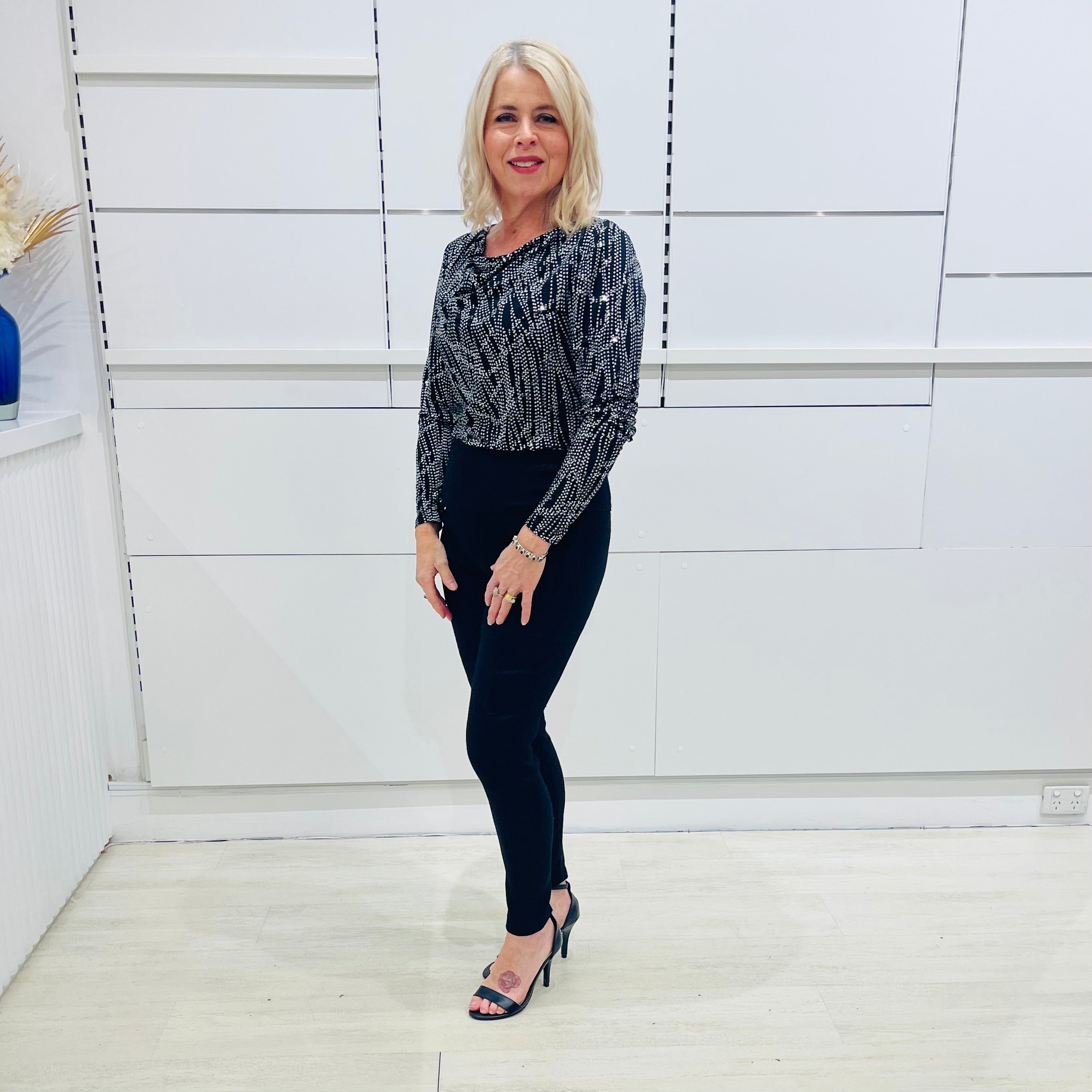 Black,white, and silver dot cowl neckline, long sleeve semi fitted top, with black fitted pants/trousers with pockets 