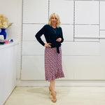Relaxed fit, black bamboo, v neckline, long sleeve, tie front detail, dressy top. Worn with midi length skirt with slight hemline ruffle in black,white and pink. 