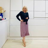 Relaxed fit, black bamboo, v neckline, long sleeve, tie front detail, dressy top. Worn with midi length skirt with slight hemline ruffle in black,white and pink. 
