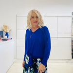 Relaxed fit, cobalt blue bamboo, v neckline, long sleeve, tie front detail, dressy top. Worn with midi length skirt with blue, black, white pattern print.