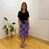Woman standing in a room with a plant and white wall