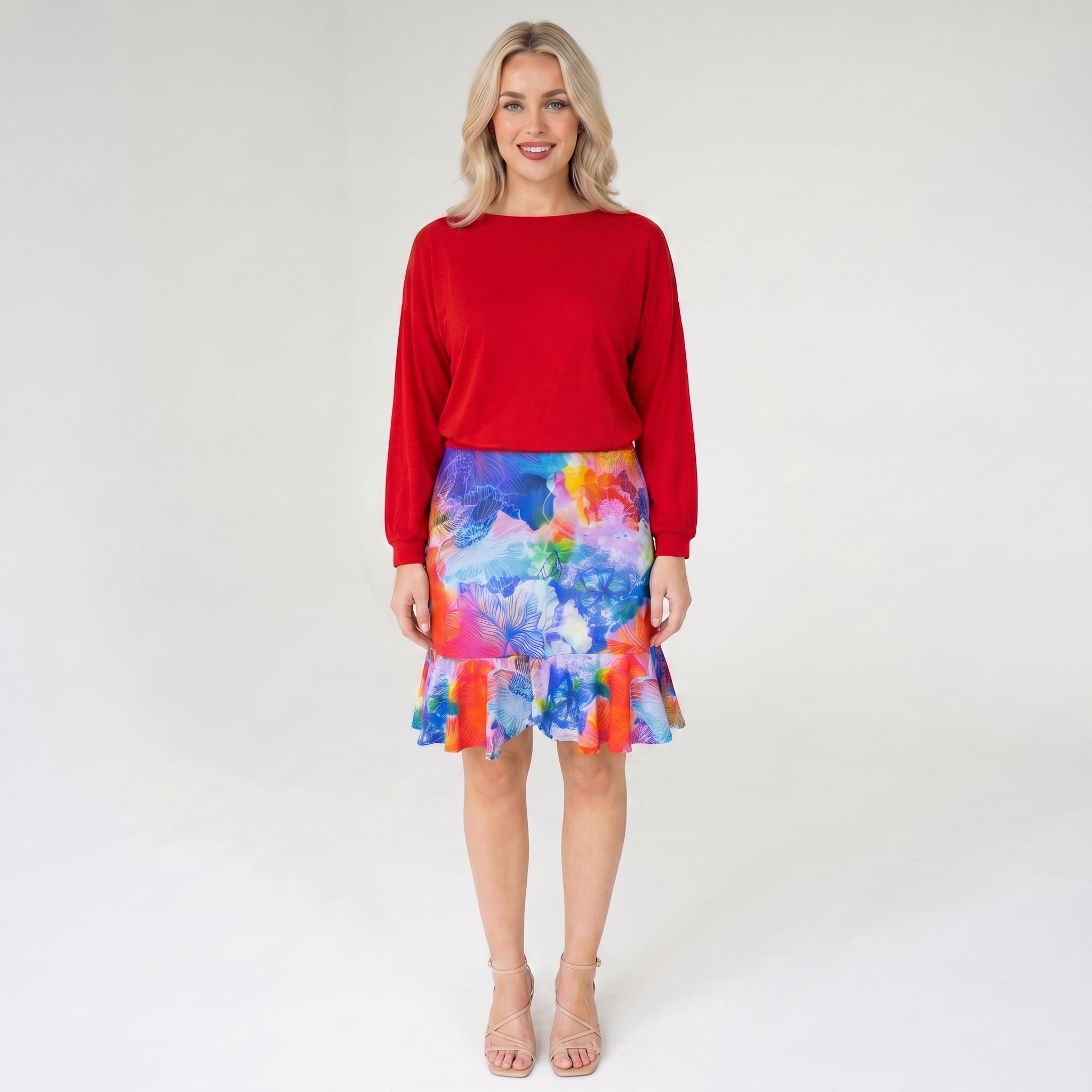 Woman wearing a red top and colorful skirt on a white background