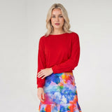 Woman wearing a red top and colorful skirt on a white background