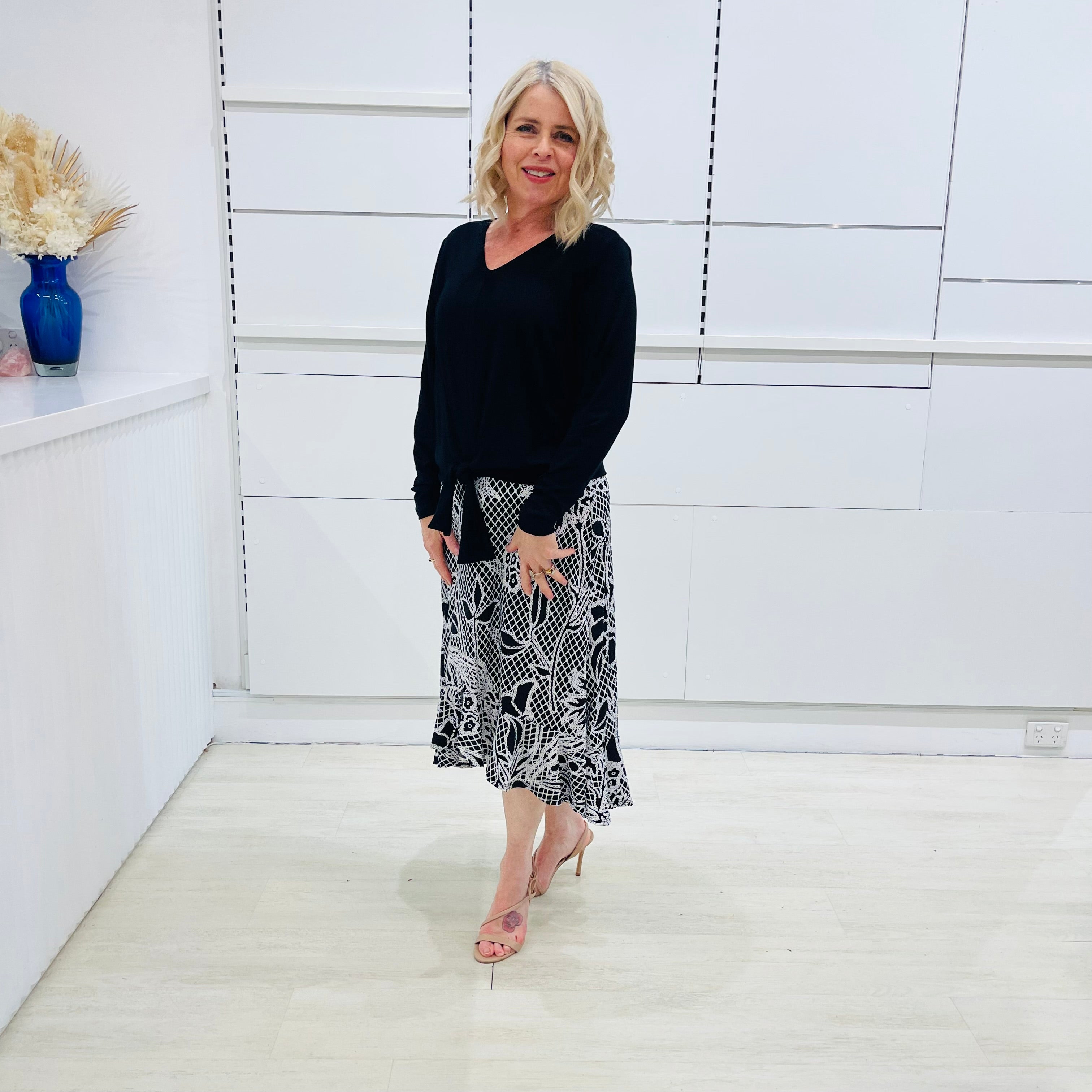 Noir garden-Black and white floral print, Rachel  Ruffle skirt, with elastic stretch waist. Worn on model with black bamboo , long sleeve, tie front, v-neckline top.