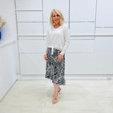Noir garden-Black and white floral print, Rachel  Ruffle skirt, with elastic stretch waist. Worn on model with white bamboo , long sleeve, tie front, v-neckline top.