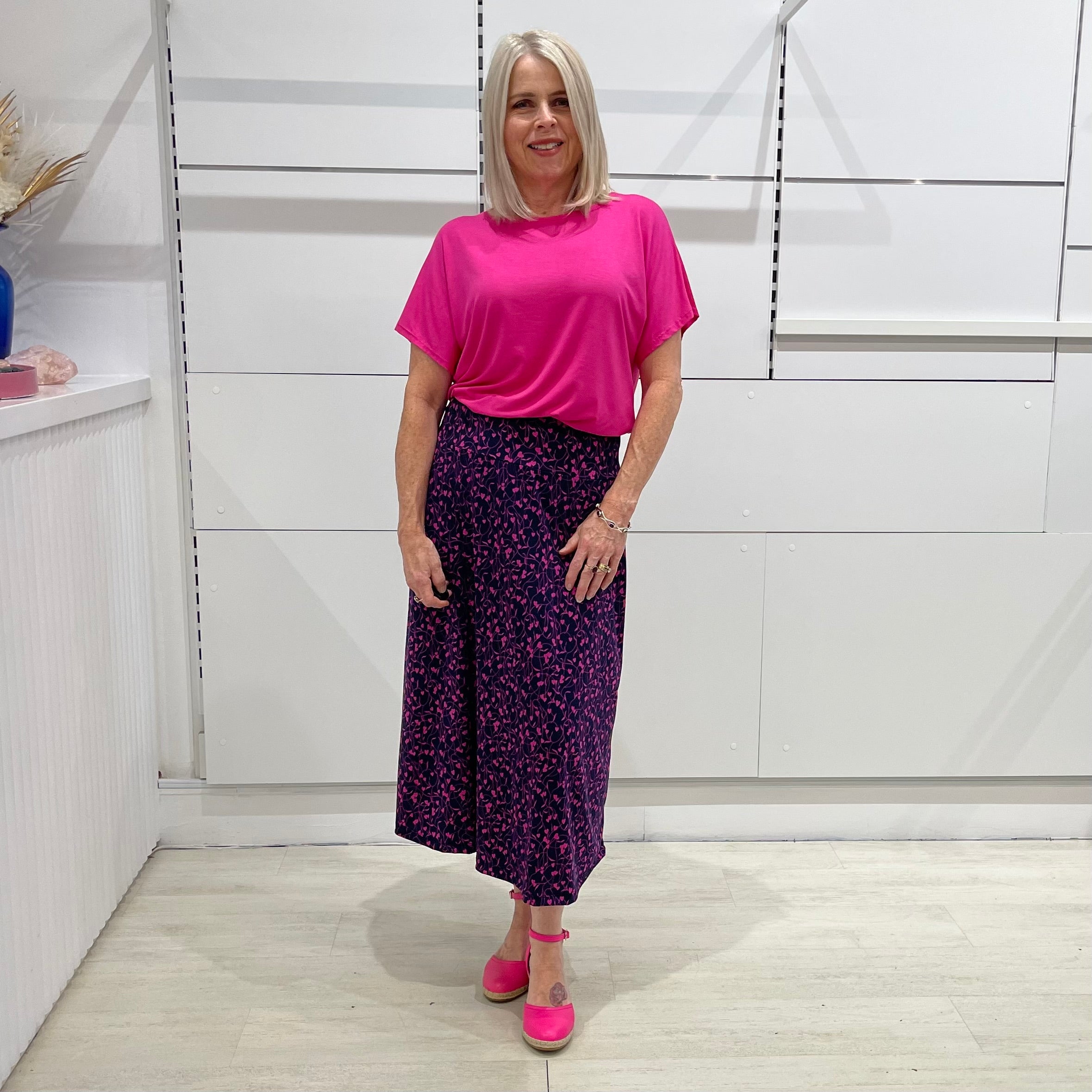 Dark navy base skirt with love heart print, ankle length skirt. Worn with bright pink short sleeve round neckline top with band on bottom 
