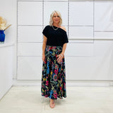 Long, maxi, full circle skirt in multicolored print, flat fitted waistband . Worn with black off the shoulder top.