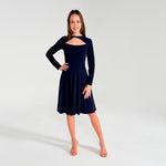 Woman in navy long sleeve dress in white room 