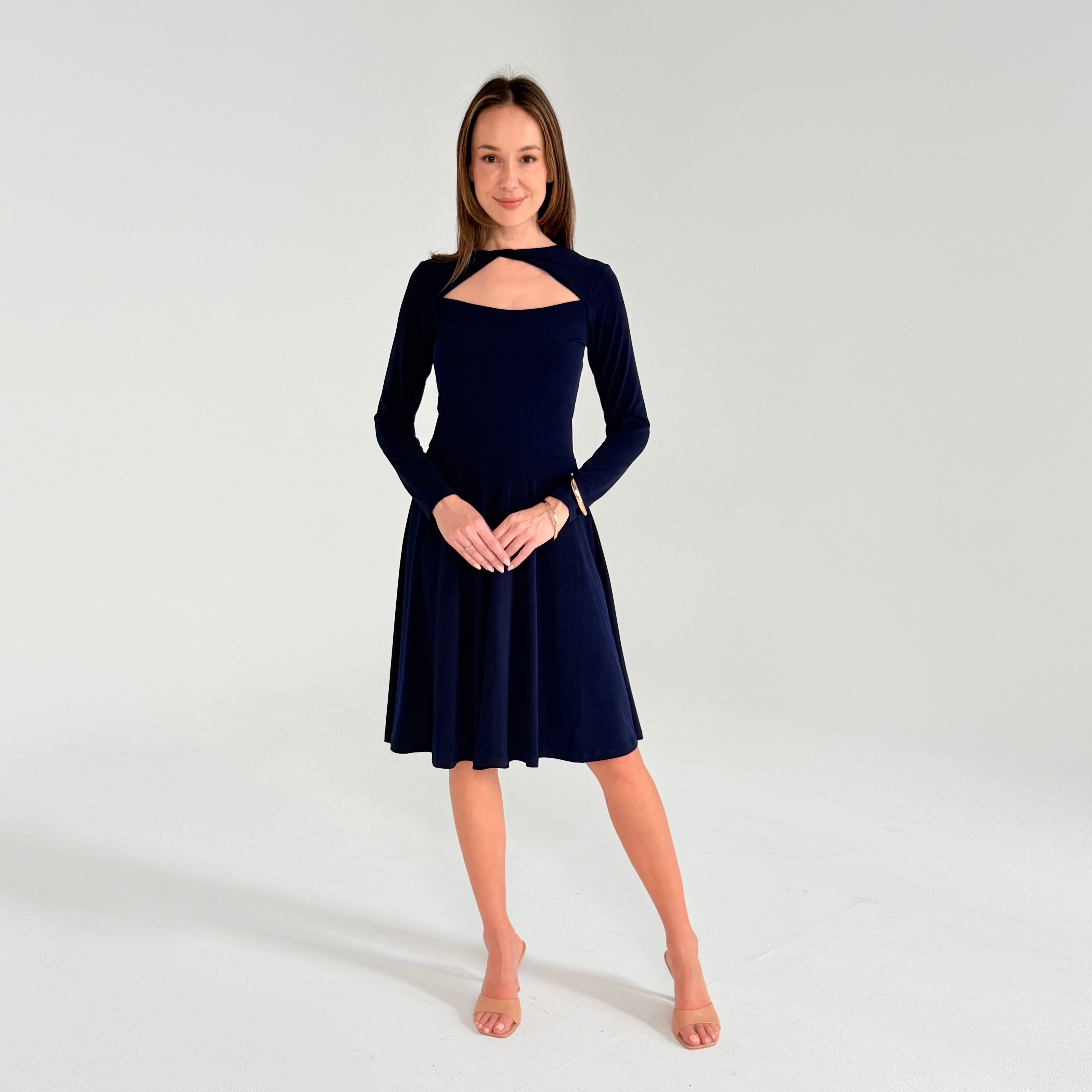 Woman wearing a navy blue dress with long sleeves on a white background