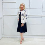 Penelope dress in deep navy blue, worn by model- elegant long sleeve design, knee length, with modern neckline, worn with Navy blue & white embroidered silk jacket, designed and Made in Australia.