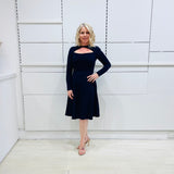 Penelope dress in deep navy blue, worn by model- elegant long sleeve design, knee length, with modern neckline.