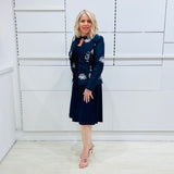 Penelope dress in deep navy blue, worn by model- elegant long sleeve design, knee length, with modern neckline, worn with Navy blue & white embroidered silk jacket, designed and Made in Australia.
