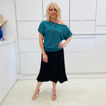 Stunning off the shoulder emerald green top with delicate shimmer. Flattering relaxed fit cut with stretch waistband for style and fit. Worn with black stretch skirt with asymmetrical hemline small ruffle detail.