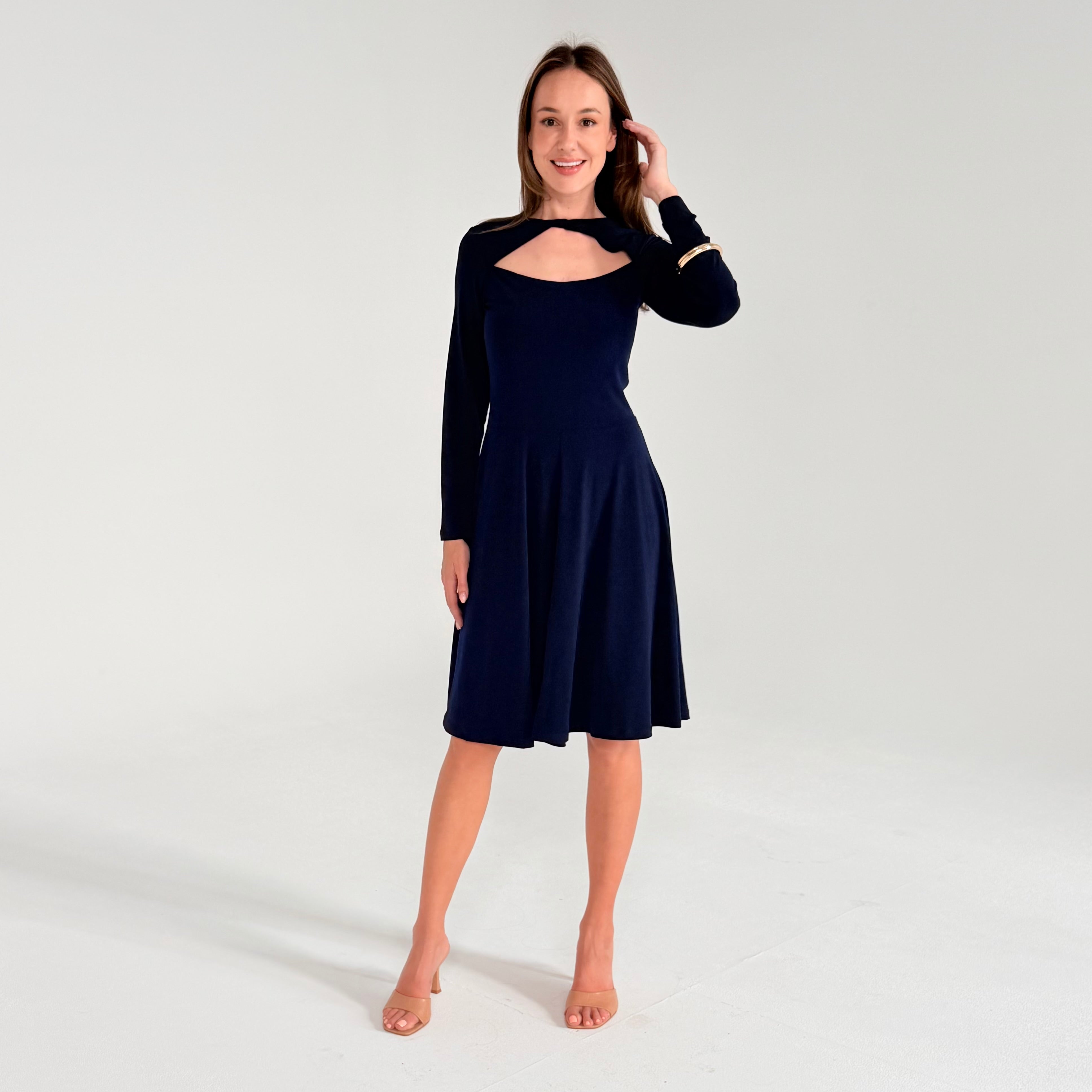 Woman wearing a black dress with long sleeves on a white background