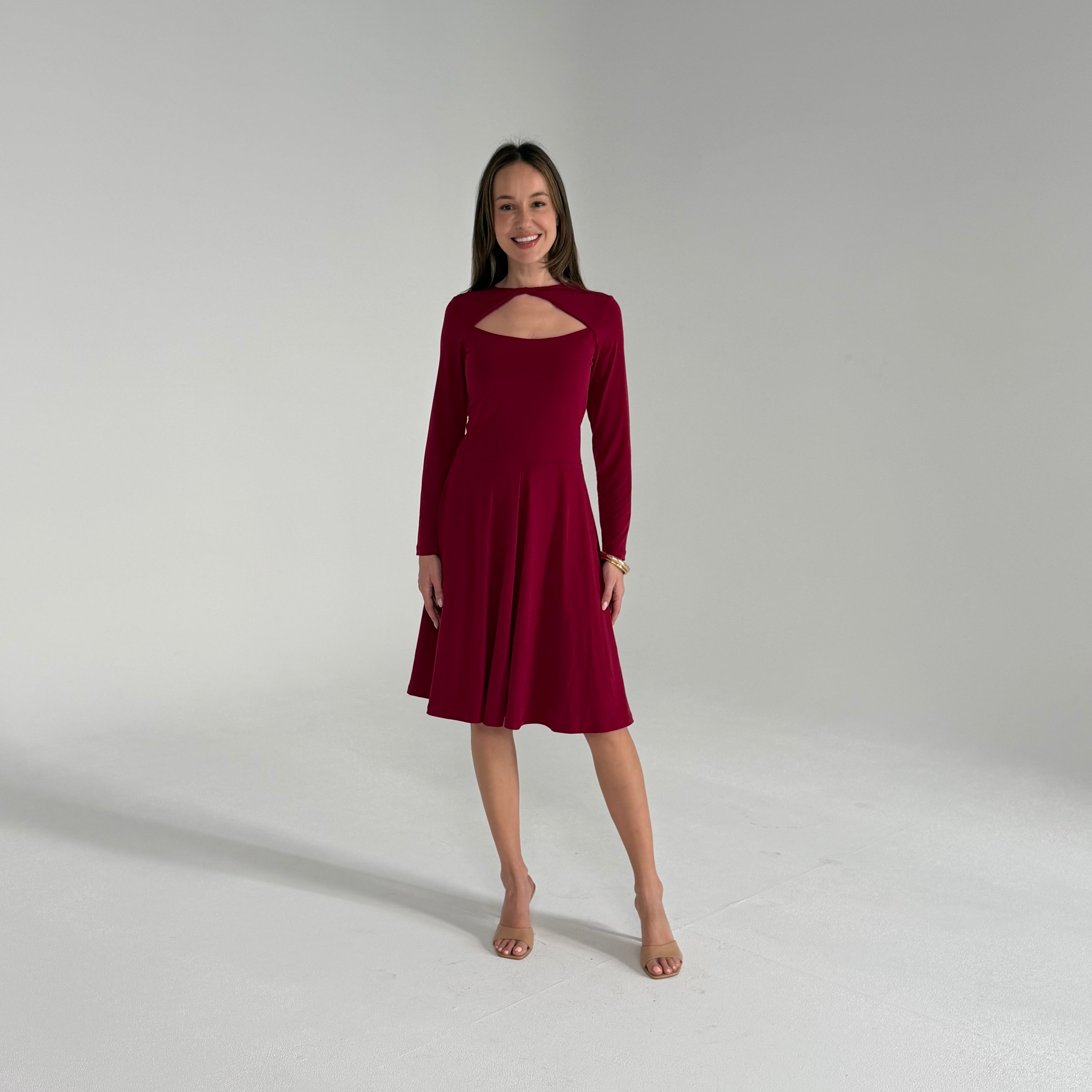 Woman wearing a burgundy dress on a plain background