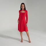Woman wearing a red dress with long sleeves on a plain background
