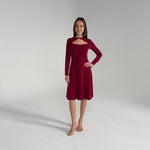 Woman wearing a burgundy dress on a plain background