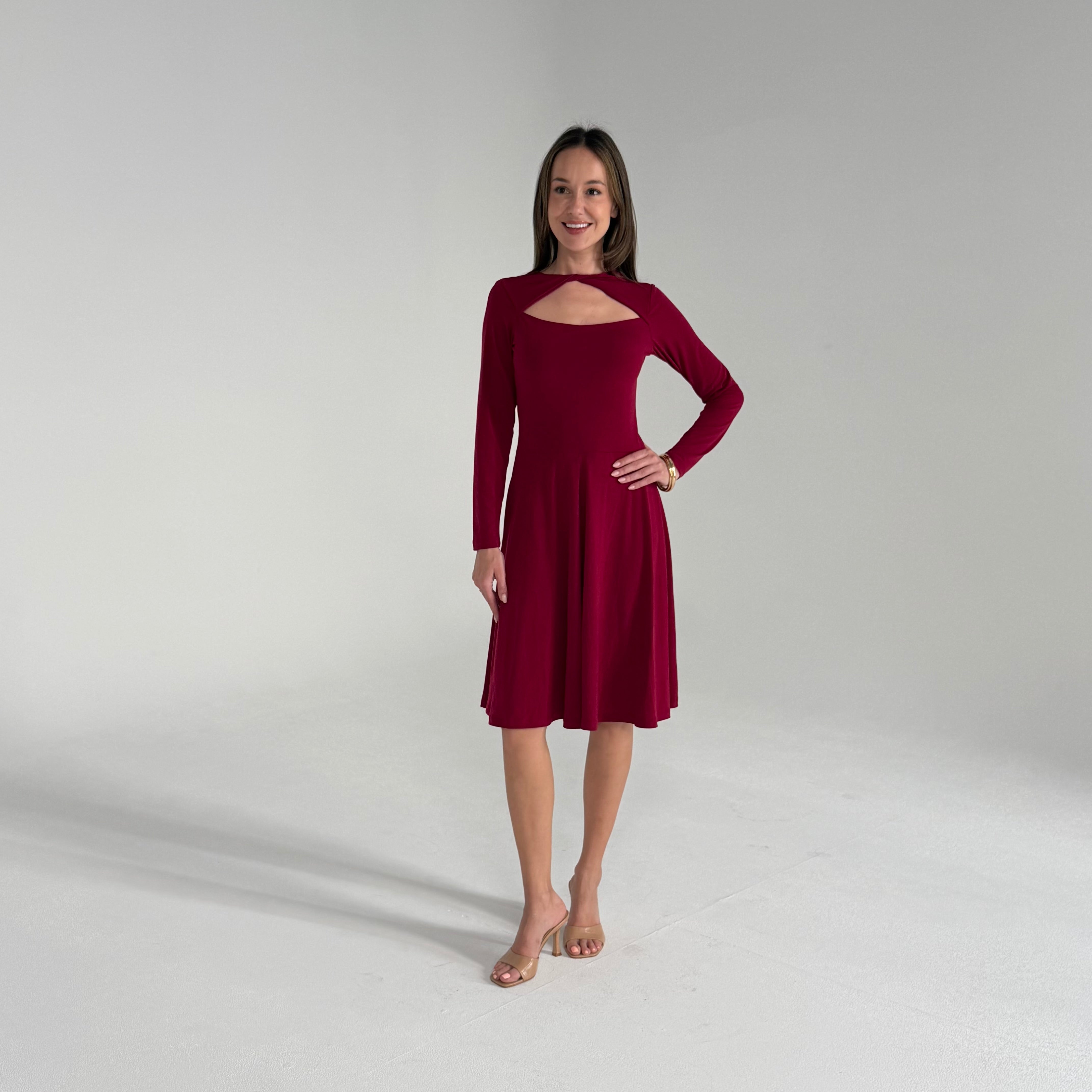 Woman wearing a burgundy dress on a plain background