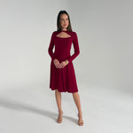 Woman wearing a burgundy dress against a plain background