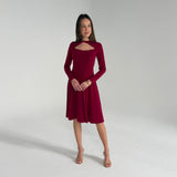 Woman wearing a burgundy dress against a plain background