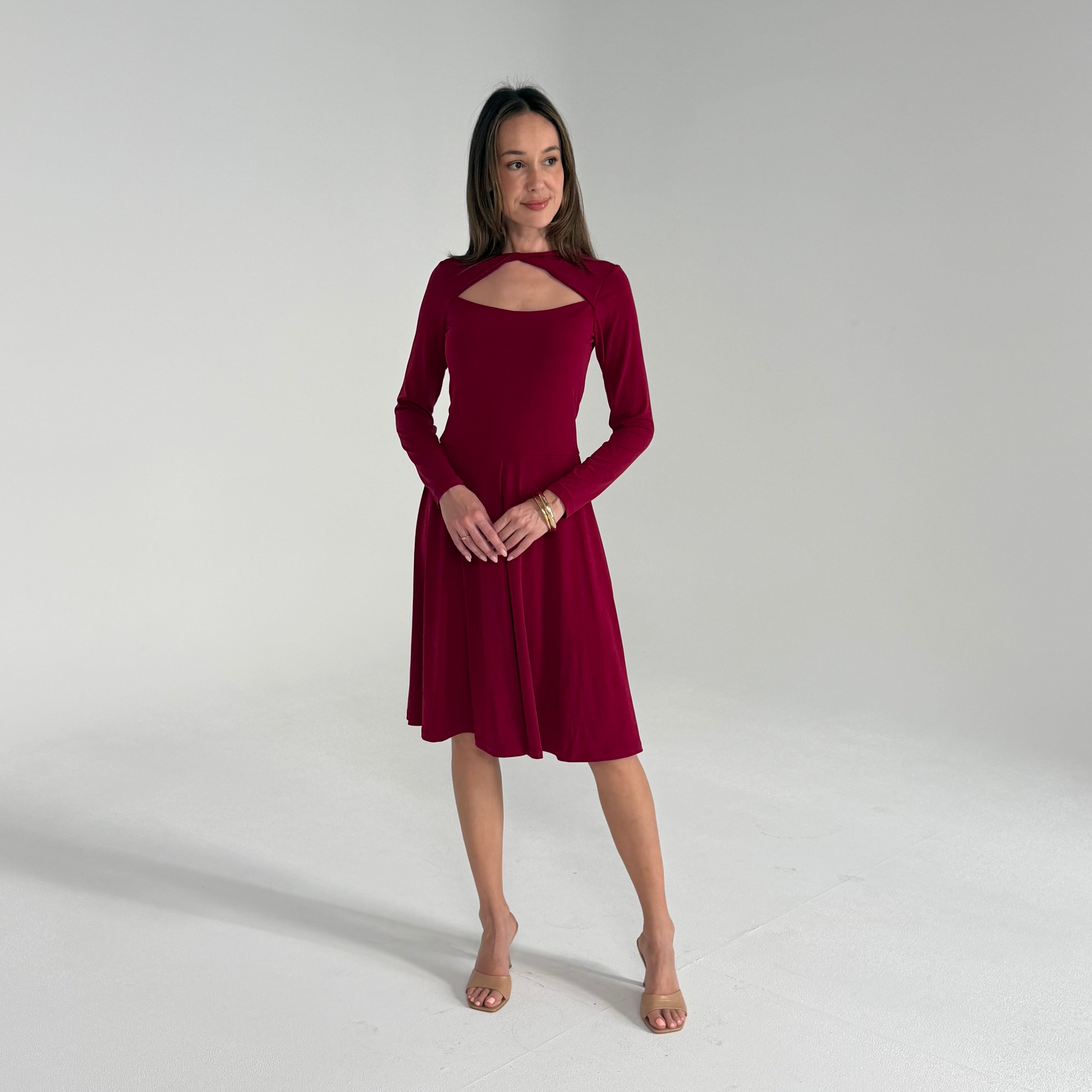Woman wearing a burgundy dress against a plain background
