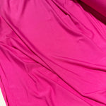 Bright pink fabric draped in soft folds, showing a smooth texture and solid color.