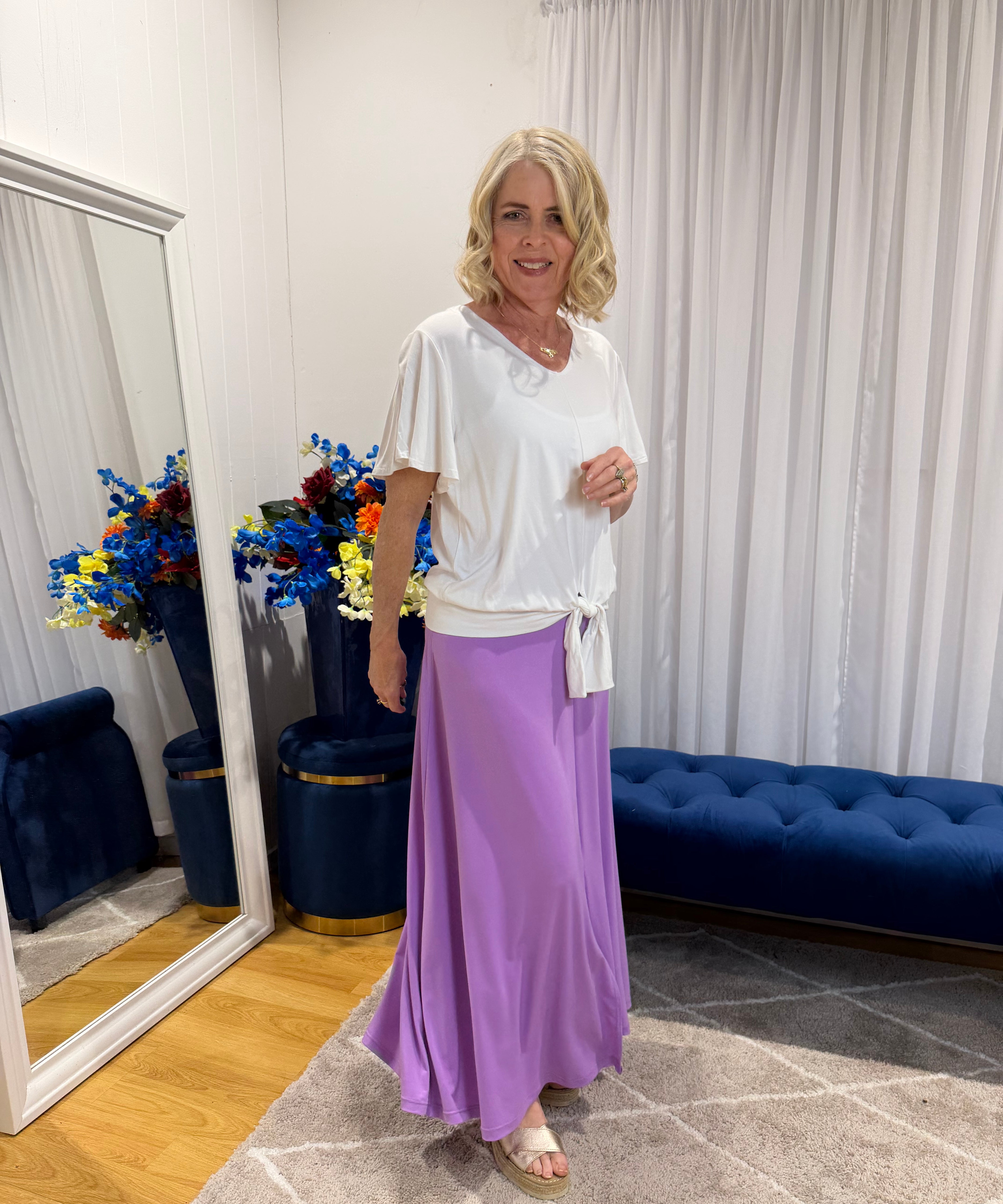 Woman wearing white top and purple skirt 