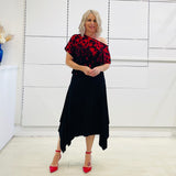 Black & red floral print, off the shoulder, asymmetrical neckiline, relaxed fit top, worn with black, handkerchief hemline skirt with elastic waistband.
