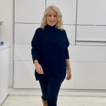 Relaxed fit loose line, long line, long sleeved, black knit jumper/sweater. With black pants and knee high leather boots 