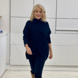 Relaxed fit loose line, long line, long sleeved, black knit jumper/sweater. With black pants and knee high leather boots 