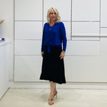 Relaxed fit, cobalt blue bamboo, v neckline, long sleeve, tie front detail, dressy top. Worn with midi length skirt with slight hemline ruffle in black.