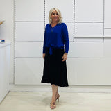 Relaxed fit, cobalt blue bamboo, v neckline, long sleeve, tie front detail, dressy top. Worn with midi length skirt with slight hemline ruffle in black.